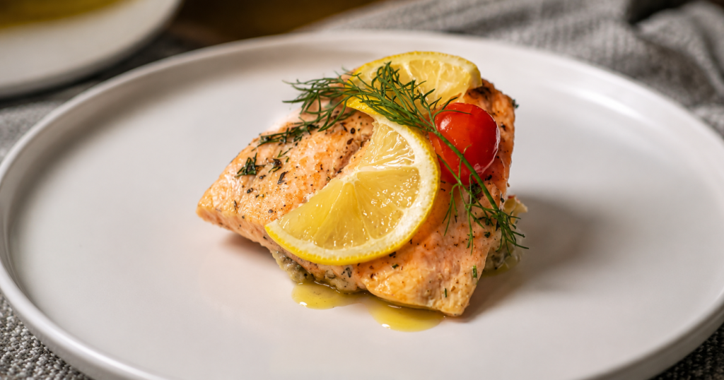 Seared salmon fillet with fresh lemon, dill and cherry tomato elegantly plated on a white plate by BontleFela Culinary Experience