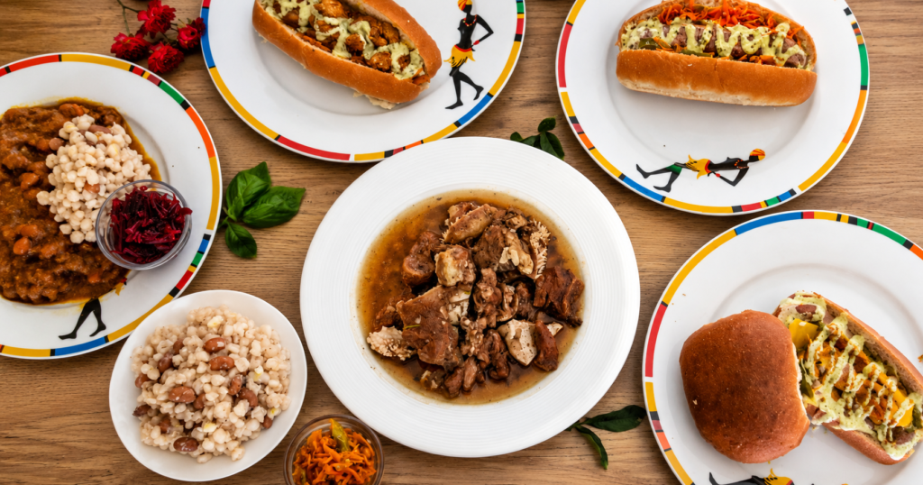 Modern African feast featuring slow cooked cow head "Nhloko - a treasured African delicacy served with Samp & Beans, gourmet filled rolls, and fresh chakalaka - an authentic South African cuisine.